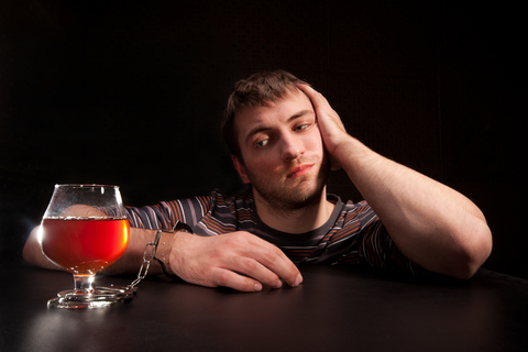 man locked to glass of alcohol